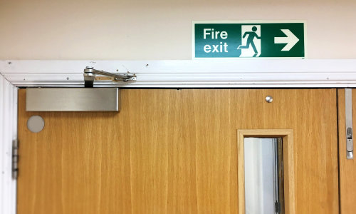 Fire door with door closer and fire exit signage