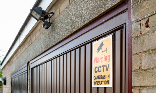 Garage door with CCTV sign