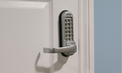 Mechanical digital door lock with lever handle operation on a timber internal door.
