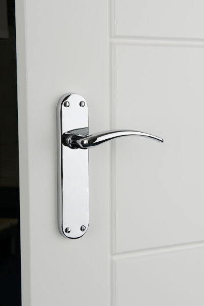Polished chrome door handle on white door